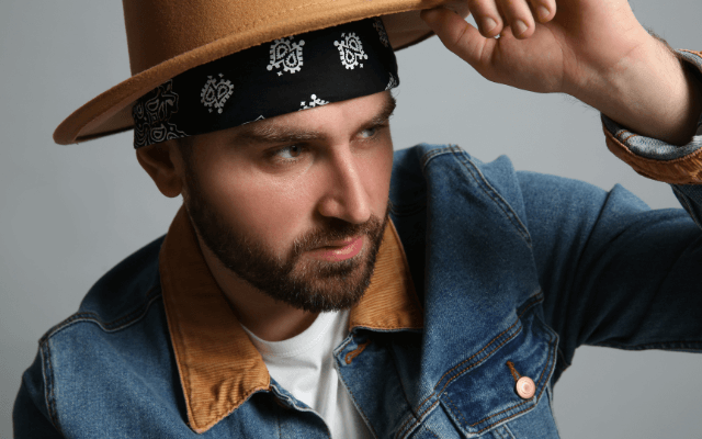 Fashionable young man in with bandana on grey background