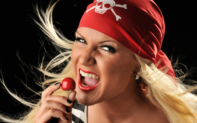 Beautiful pirate holding a red cherry