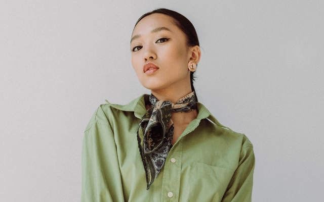 A pretty woman in a retro outfit wearing a bandana on her neck.