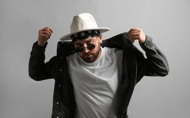 A male model in a stylish outfit wearing a black and white bandana.